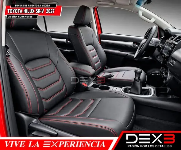 Interior de camioneta Toyota Hilux SR-V con fundas de asientos a medida en color negro y costuras rojas con diseño de corchetes